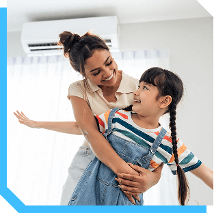Mother hugging her daughter near an air conditioner, showing home comfort in North Atlanta Metro.